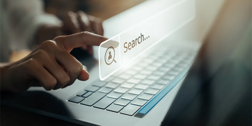 Hand pointing at a virtual search bar on a laptop, representing SEO poisoning risks in search engines and the role of SEO service Gold Coast in prevention.